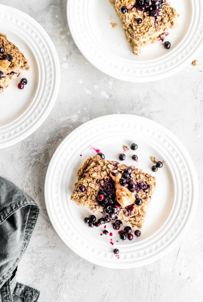 Baked oatmeal with blueberries and peanut butter on a small white plate.