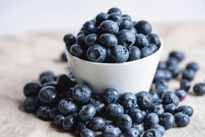 Fresh blueberries in a white bowl.