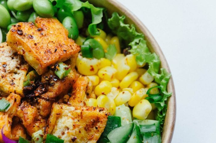 Tofu, corn and lettuce in a bowl.