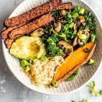 Overhead shot of a vegan tempeh bacon, avocado, kale and mushroom sweet potato breakfast bowl.