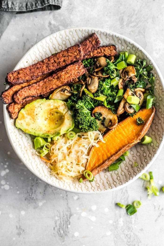 Overhead shot of a vegan tempeh bacon, avocado, kale and mushroom sweet potato breakfast bowl.