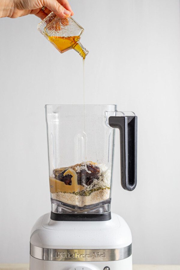 Syrup being poured into a blender.