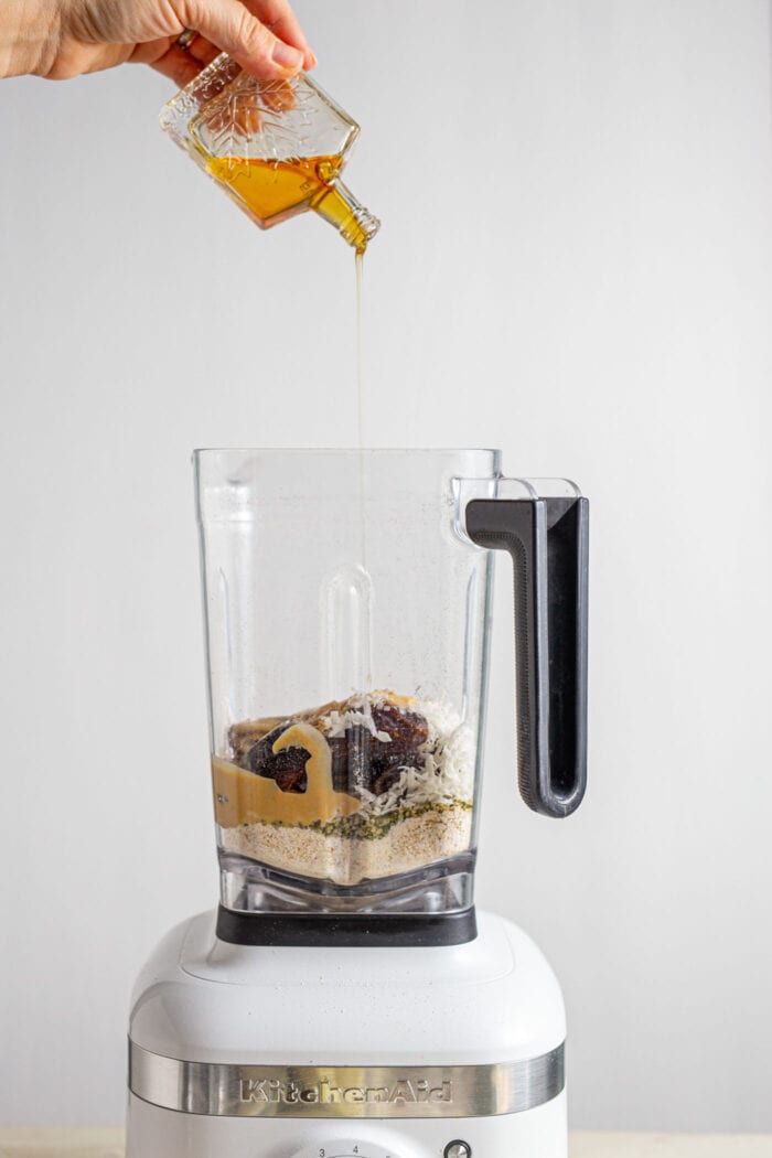 Syrup being poured into a blender.