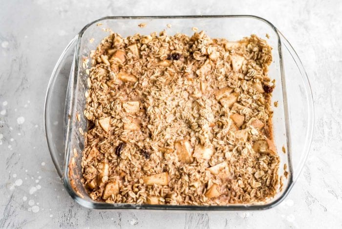 Baked apple cinnamon oatmeal in a square glass baking dish.