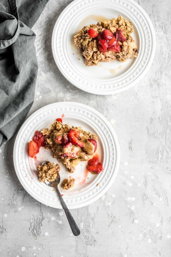 Easy Vegan Apple Cinnamon Baked Oatmeal on a plate with strawberries and almond butter.
