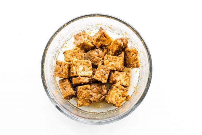 Marinated tempeh in a small glass dish.