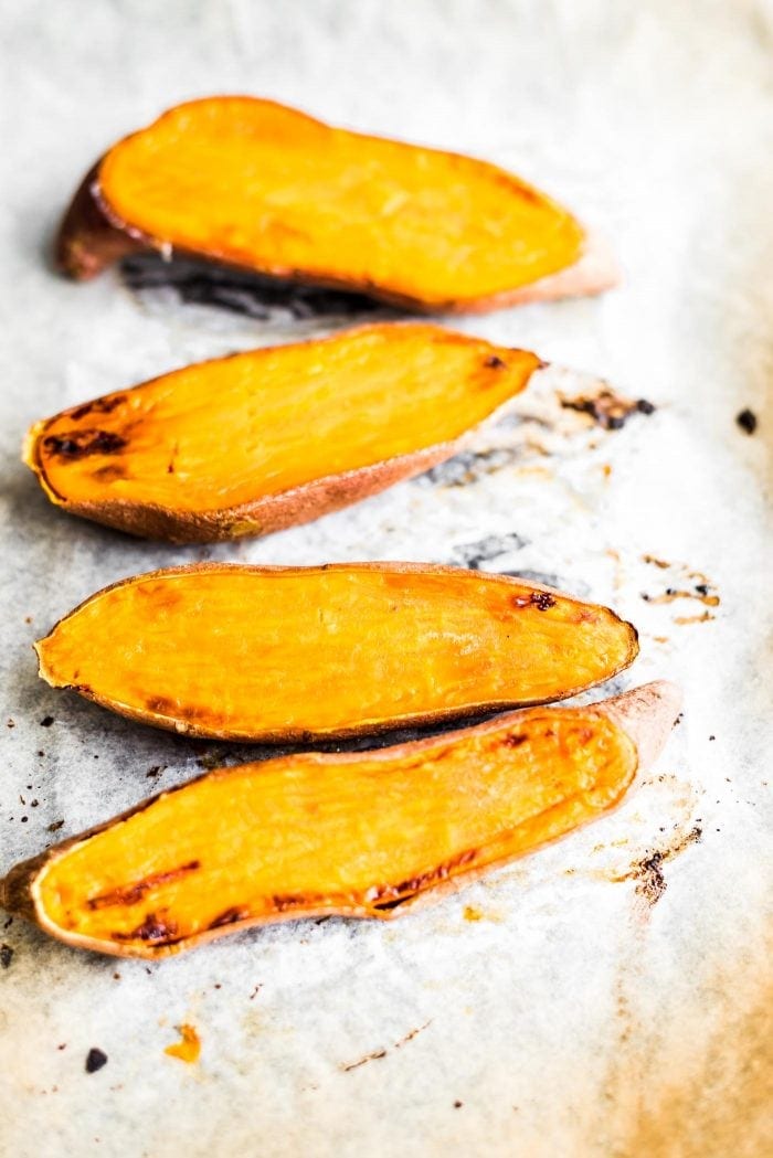 Roasted sweet potatoes on a baking tray - Vegan Essentials.