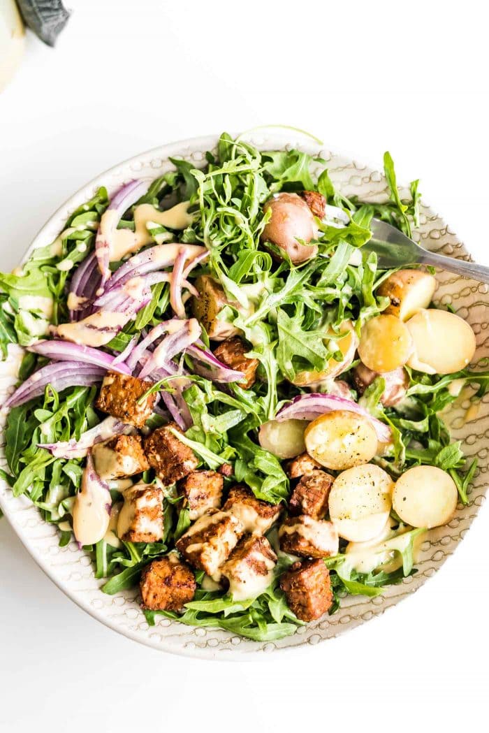 Red onion, tempeh and boiled potato arugula salad with dijon dressing.