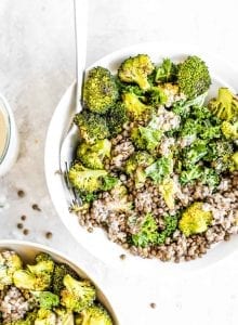 French lentils in a bowl with kale, roasted broccoli and tahini.