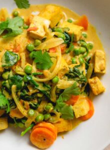 Bowl of mixed vegetable curry topped with cilantro.