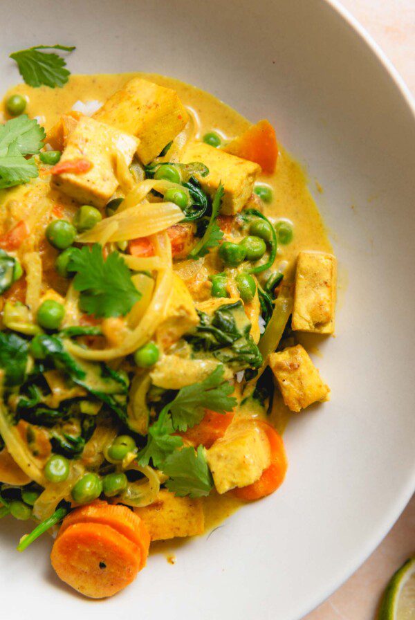 Bowl of mixed vegetable curry topped with cilantro.