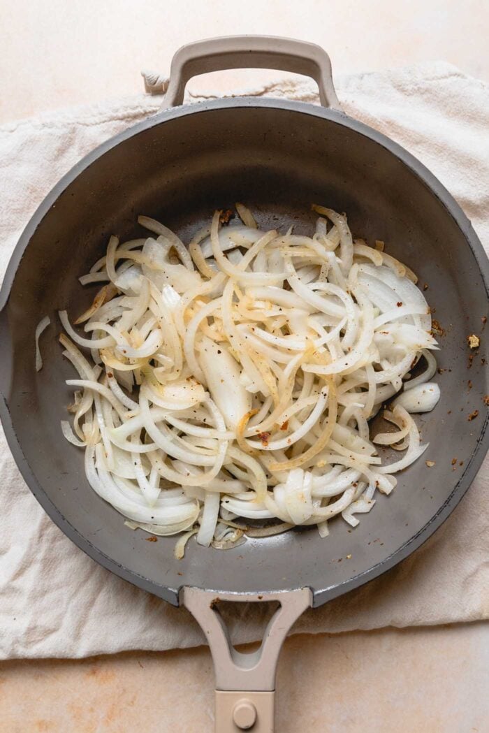 Sliced onions cooking in a pan.