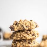 Stack of three gluten-free vegan chocolate chip quinoa cookies against a grey background.