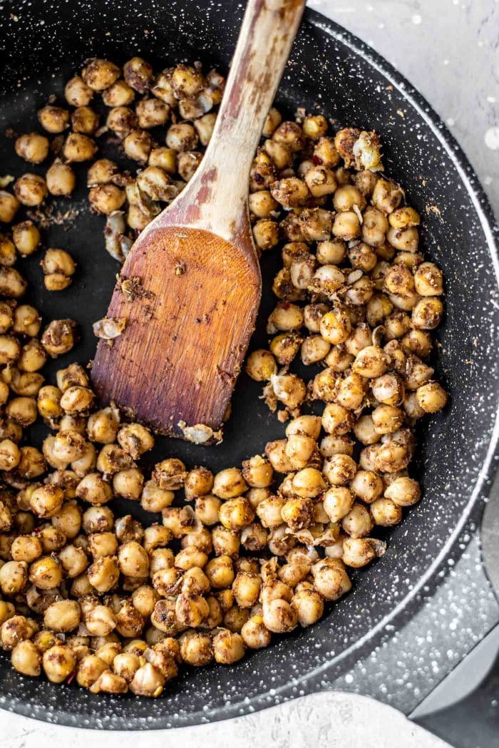 Shawarma chickpeas with spices in a black skillet.