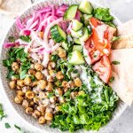 Salad with shawarma chickpeas, kale, parsley, pickled onions, pita and tomato.