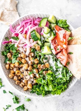 Salad with shawarma chickpeas, kale, parsley, pickled onions, pita and tomato.