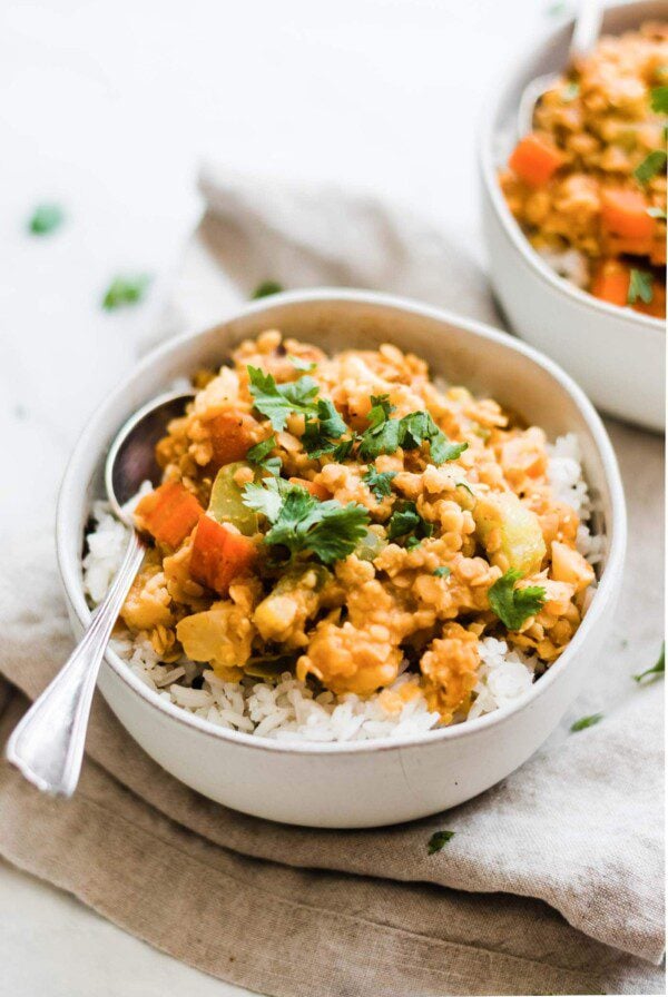 White bowl filled with red lentils and vegetables.