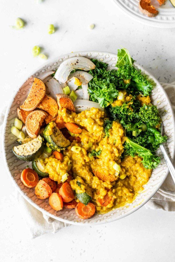 Curried lentils, kale and roasted vegetables in a bowl.