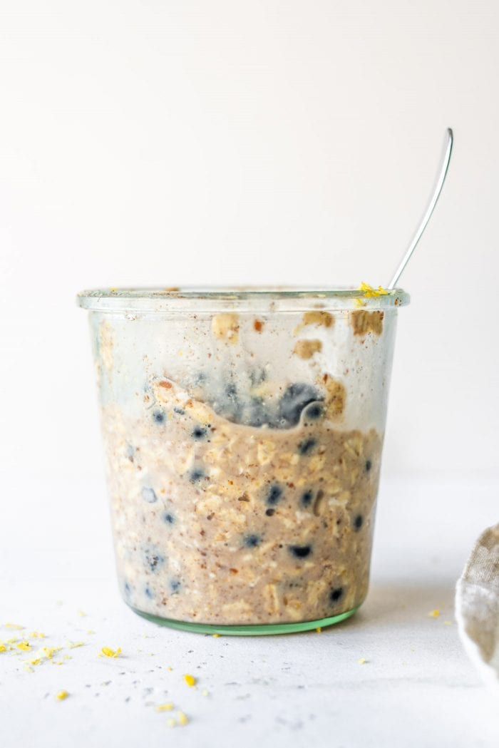 Glass jar filled with blueberry overnight oats.