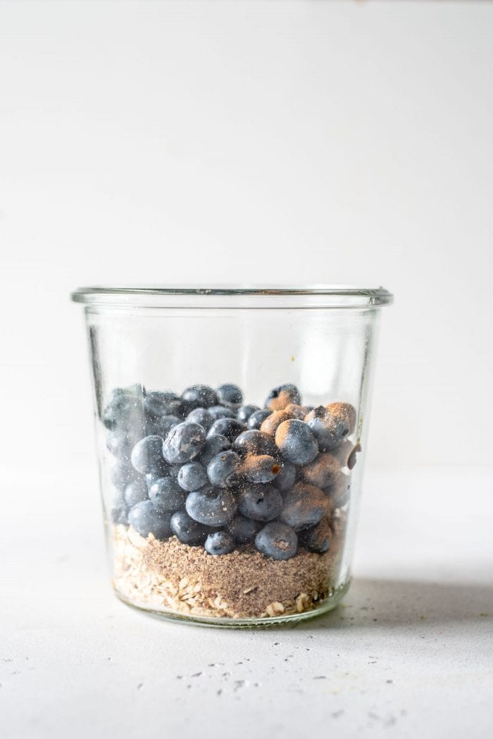 Oats, flax, lemon and blueberries in a glass jar.