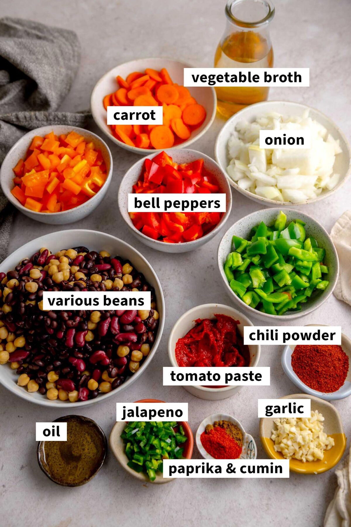 All the ingredients for making a vegan 3 bean chili recipe with bell peppers, onions and beans. Each ingredient is chopped up an in a small bowl or dish.