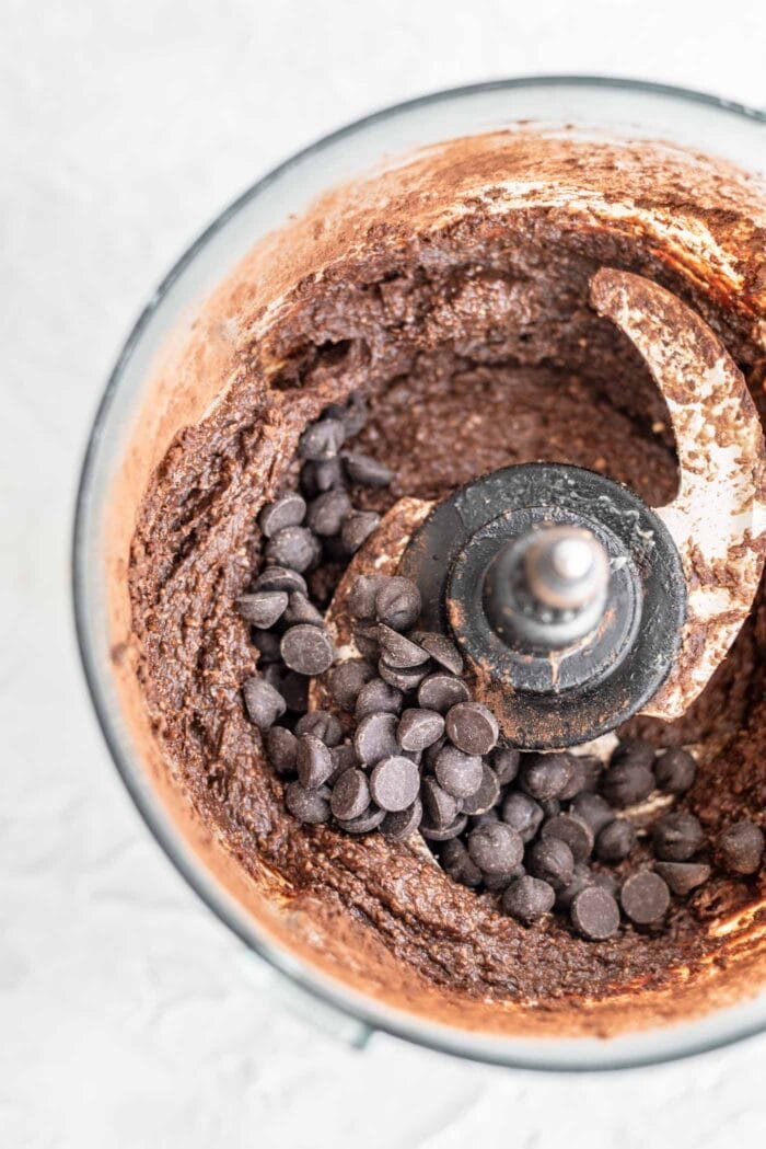 Thick chocolate batter with chocolate chips in a food processor.