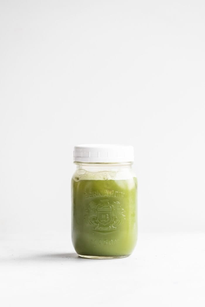 Iced green tea matcha in a glass mason jar with a white lid.