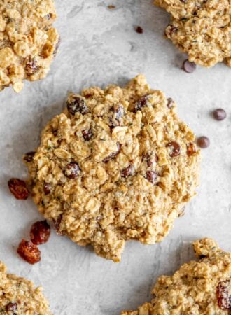 A close up of a oatmeal cookie with raisins and chocolate chips.