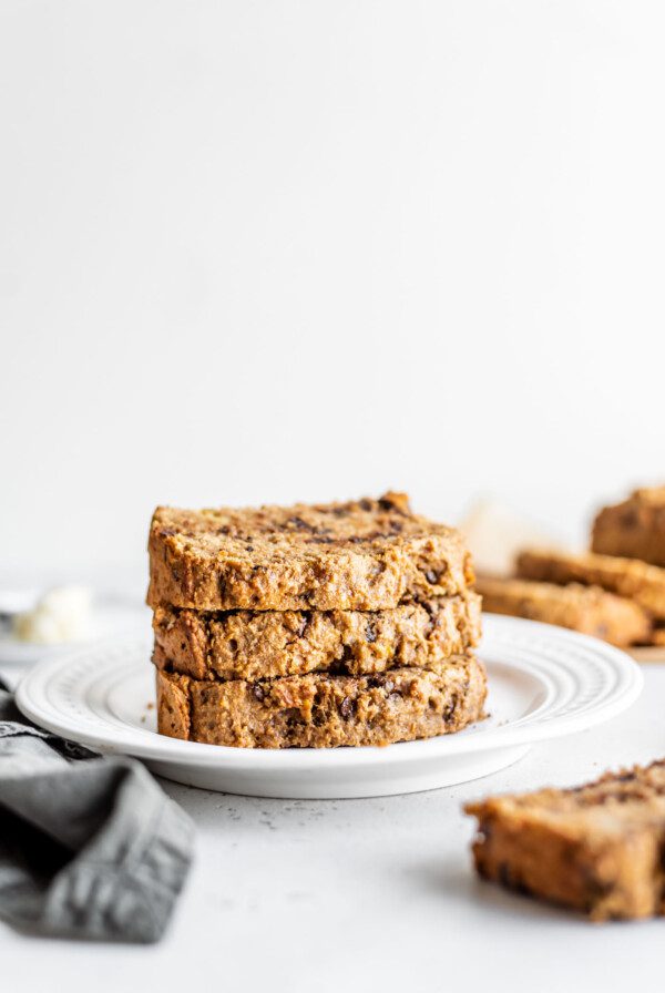 Stack of 3 slices of easy vegan banana bread on a white plate.