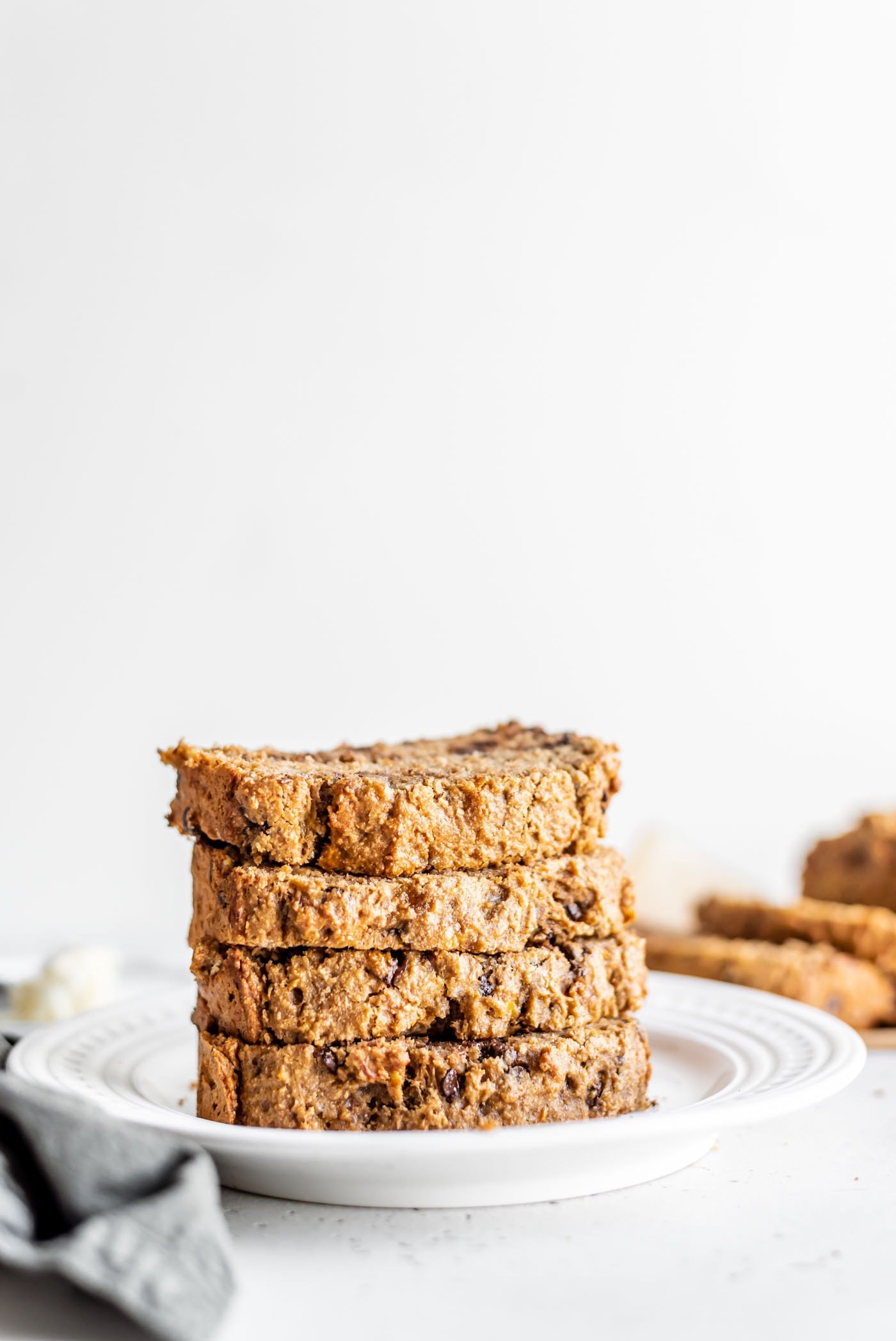 Stack of 5 slices of easy vegan banana bread on a white plate.