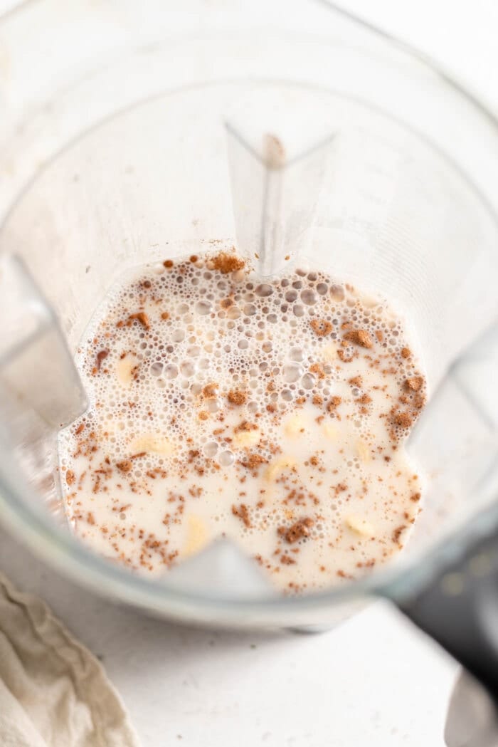 Almond milk, cashews, dates, nutmeg and cinnamon in a blender container.