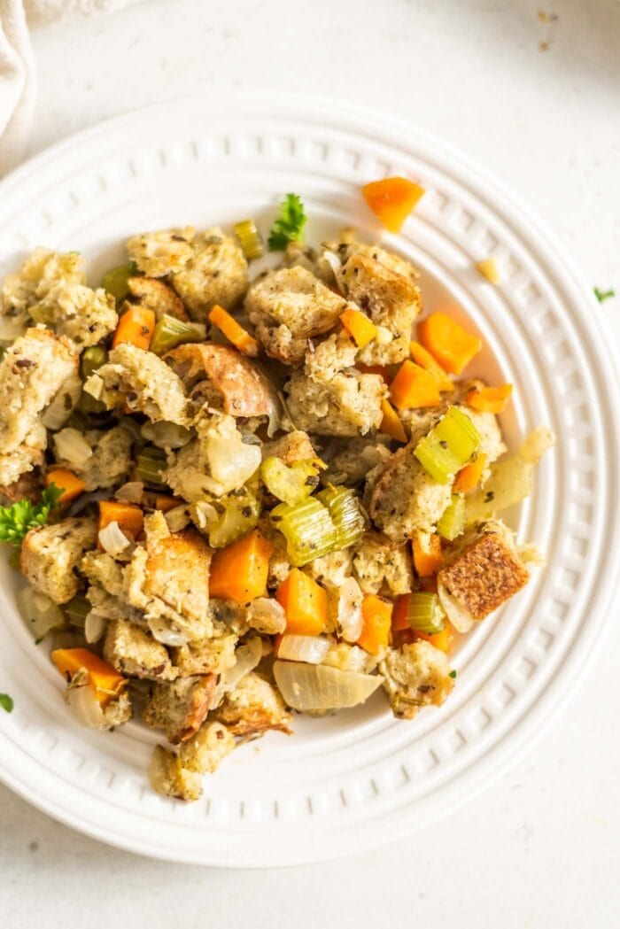 Plant-based stuffing made with cubed bread and vegetables on a small plate.