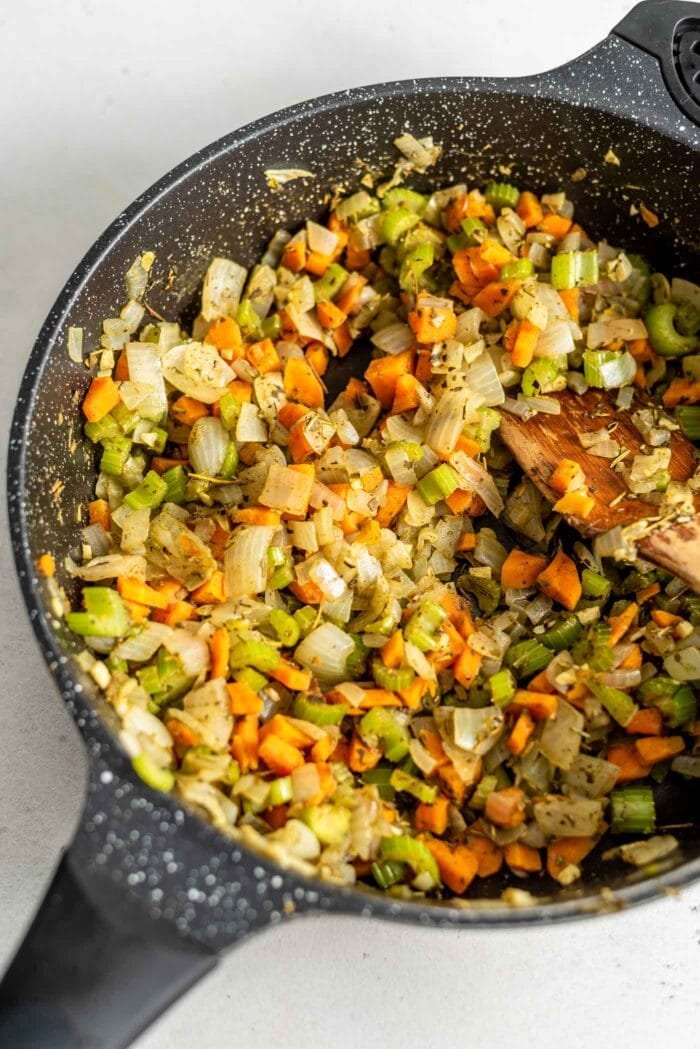 Sauteed garlic, onion, celery and carrot in a skillet.