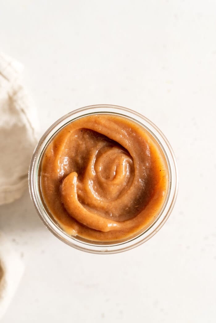 Overhead image of apple butter in a glass jar.
