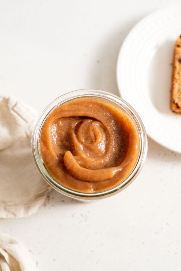 Thick apple butter in a glass jar.