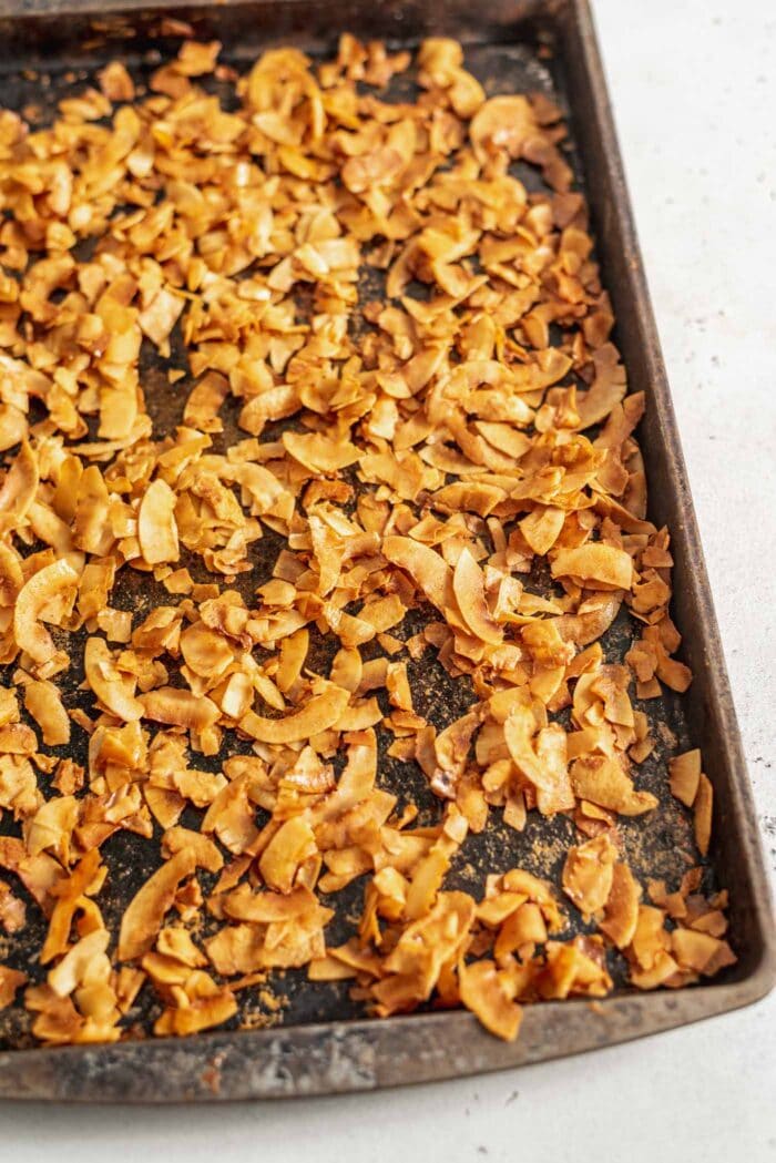 A baking tray full of golden brown coconut bacon.