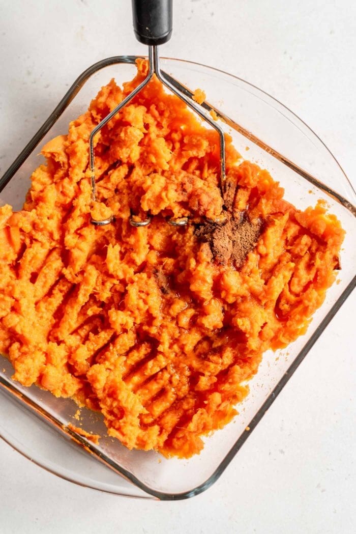 Mashed sweet potato with maple syrup in a baking dish.