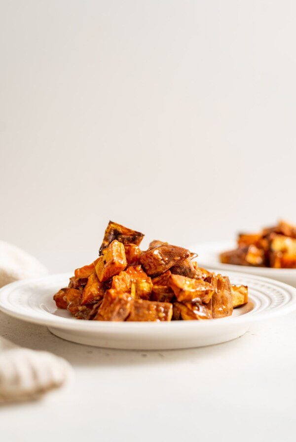 Miso glazed sweet potato on a small white plate.