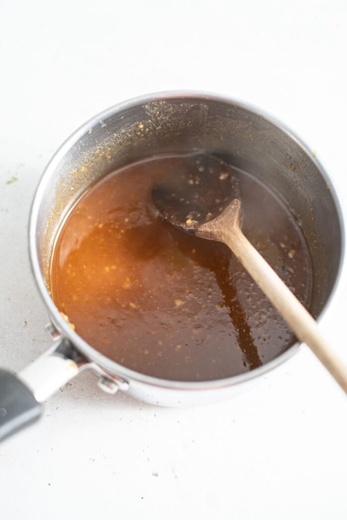 Miso glaze with a wooden spoon in a small saucepan.