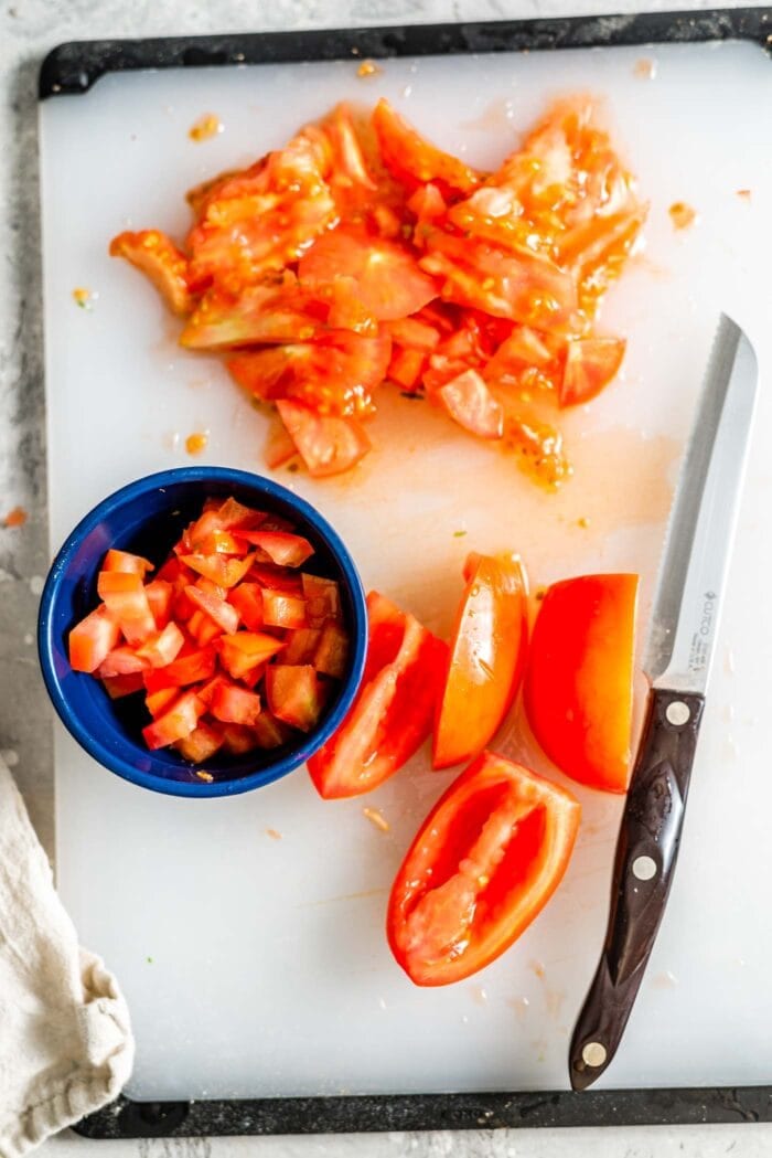 Sliced roma tomato on a cutting board.