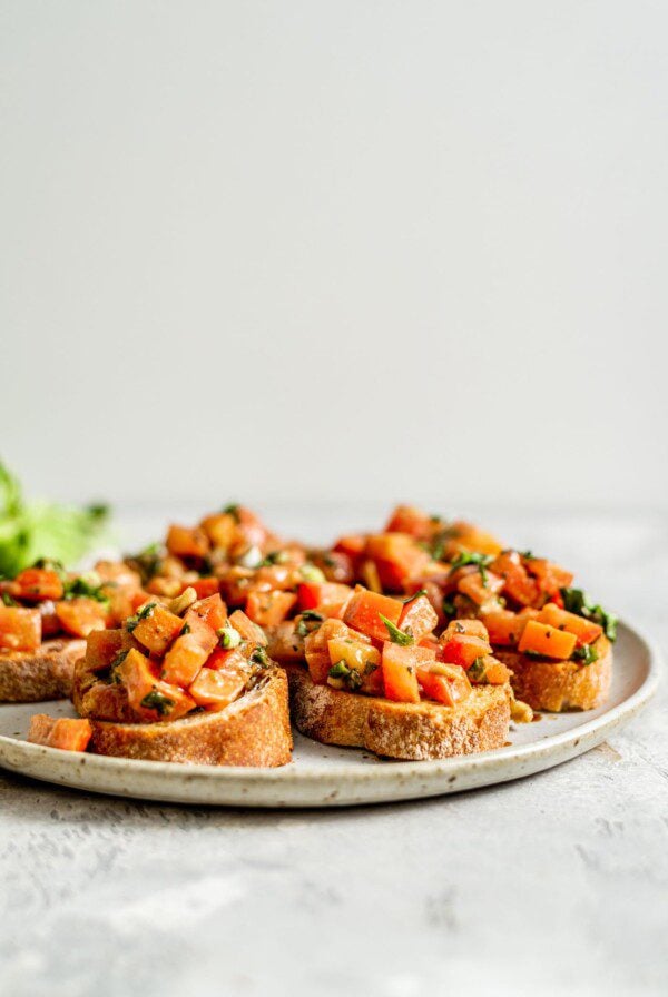 Pieces of vegan bruschetta on a plate.