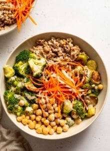 Roasted Brussels sprouts, broccoli, farro, chickpeas and carrot in a bowl.