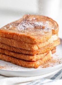 A big stack of french toast sprinkled with powdered sugar.