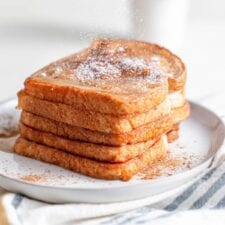 A big stack of french toast sprinkled with powdered sugar.