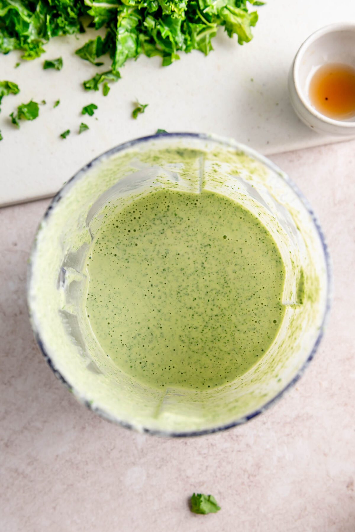 A creamy green tahini dressing in a small blender container.