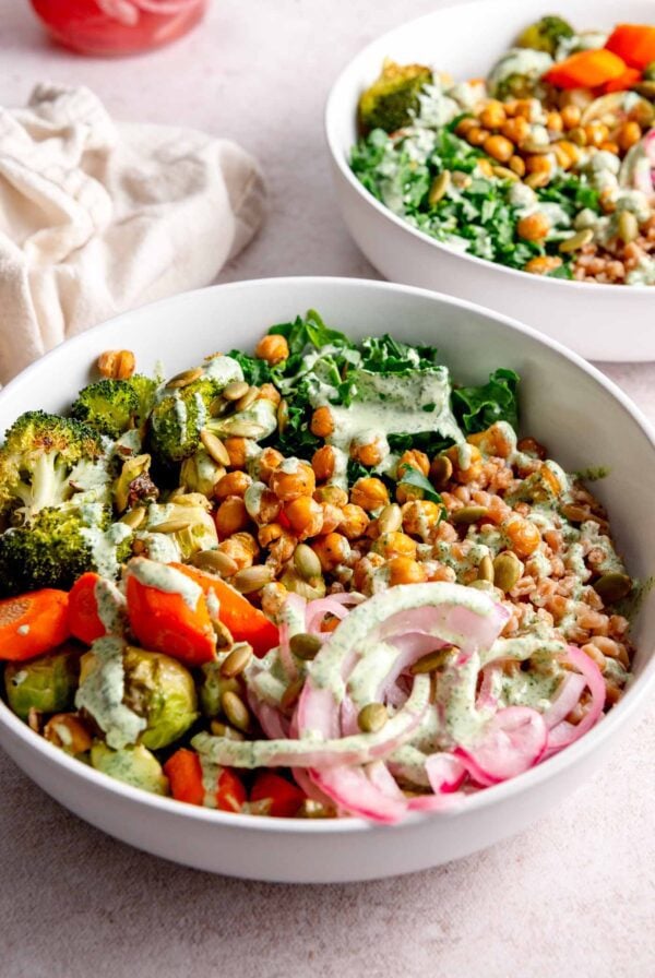 Farro bowl with roasted chickpeas, roasted chickpeas, broccoli, carrot, brussels sprouts, pickled onion and a creamy sauce.