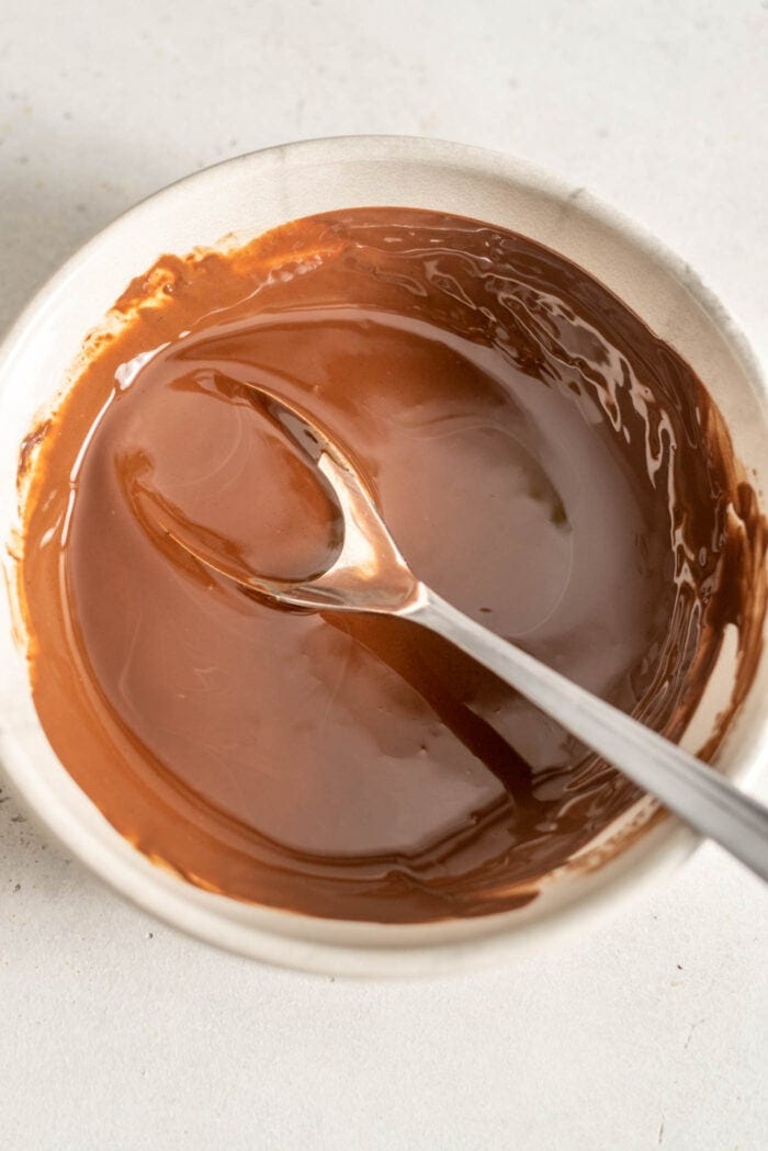 Melted chocolate in a bowl with a spoon.