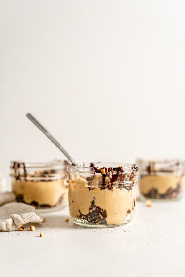 3 peanut butter mousse parfaits in small glass jars.