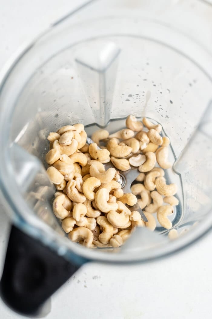 Raw cashews in a blender with water.