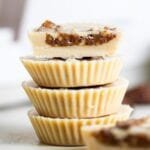 A stack of 4 tahini cups with dates inside, one cut in half to show inside.